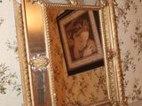 a mirror on a table in a room with a wallpapered wall