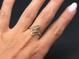 a woman ' s hand with white nails and a gold ring