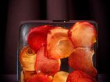 a glass block filled with sliced up fruit on a table