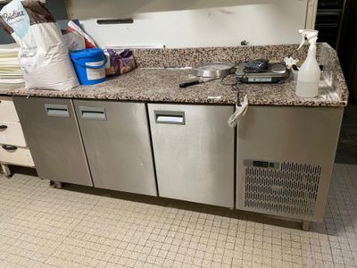 une photo d'une cuisine équipée d'appareils électroménagers et de plans de travail en inox