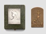 an old book with a bronze plaque of a man on a cross and a bronze plaque of a man on a cross