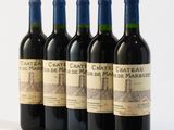 four bottles of wine are lined up on a white surface