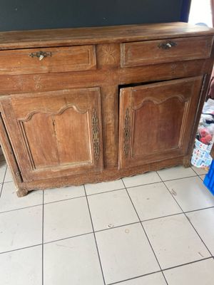 a wooden cabinet in the middle of a tiled floor
