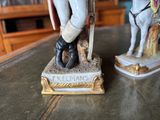two figurines of a soldier and a horse on a table