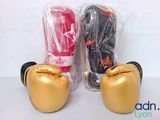 pair of gold boxing gloves sitting next to each other on a table