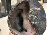 a hand holding a piece of metal with a hole in it