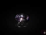 a close up of a purple diamond on a black surface