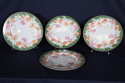 trois assiettes ornées de motifs floraux sont posées sur une surface noire