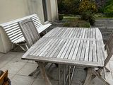 a wooden table and four chairs on the patio
