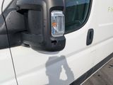 a side view mirror of a truck with a reflection of a person in the side mirror
