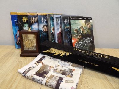 a lot of harry potter books and a clock on the table