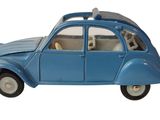 une petite voiture bleue avec une planche de surf posée dessus