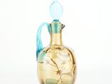 a glass vase with a blue handle on a white background