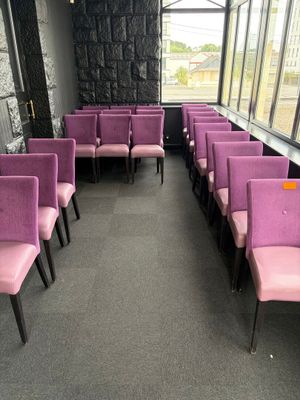 de nombreuses chaises violettes dans une pièce dotée d'une grande fenêtre