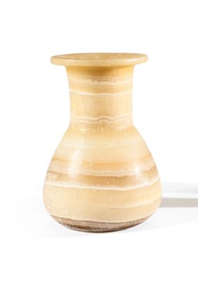 un petit vase posé sur une surface blanche