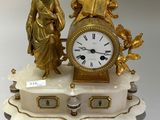 une horloge en or posée sur un socle en marbre