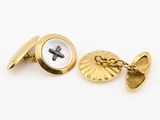a close up of a pair of gold cufflinks with a cross on it