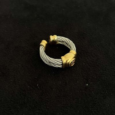 a close up of a silver and gold ring on a black surface