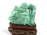 statue d'un Bouddha riant posée sur un socle en bois, sur fond blanc