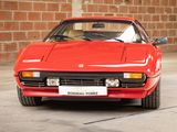 a red sports car parked in front of a brick wall