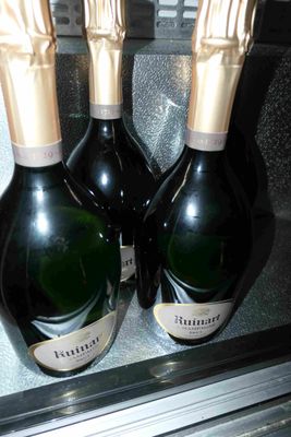 trois bouteilles de champagne posées sur le réfrigérateur
