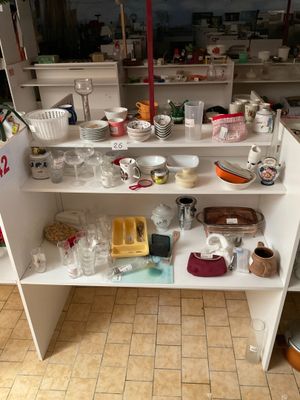 une étagère blanche sur laquelle sont posés de nombreux plats et tasses