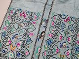 a close up of a piece of cloth with flowers and birds on it