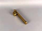 gold plated metal object on a white surface with a white background