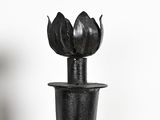 a black vase that has a flower on top of it