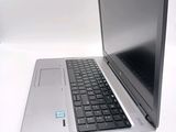 a silver laptop with a black keyboard on a white surface