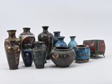 de nombreux vases de différentes couleurs posés sur une surface blanche