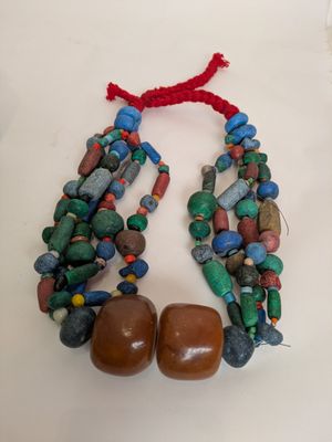 a close up of a necklace on a table with a red string