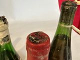 three bottles of wine sitting on a table next to a red umbrella