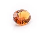 a close up of an orange diamond on a white surface