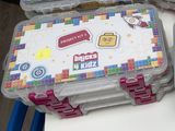 deux boîtes en plastique ornées de Lego, posées sur une table