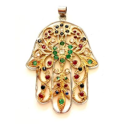 une photo d'un pendentif en forme de main de Hamsa en or, orné de pierres multicolores