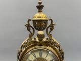 a gold clock that is sitting on top of a table