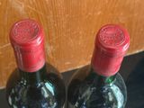 two bottles of wine sitting next to each other on a table