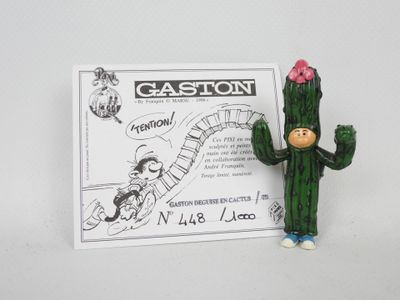 une petite figurine représentant un cactus, avec une pancarte en arrière-plan