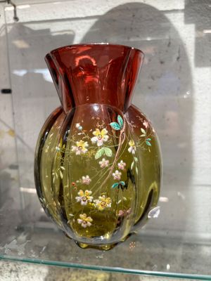 un vase en verre orné de fleurs, posé sur une étagère en verre