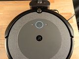 une photo d'un aspirateur robot posé sur une table en bois