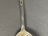 a silver spoon with a design on it on a table