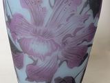 a vase with a purple flower on it sitting on a table