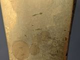 a close up of a gold vase on a table