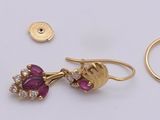 two pairs of earrings, a ring, and a ring on a white surface