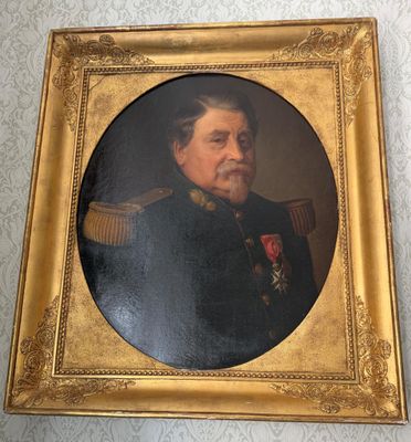 une vieille photo d'un homme en uniforme militaire dans un cadre doré