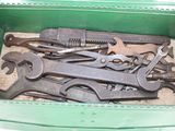 many wrenches in a green box on the table