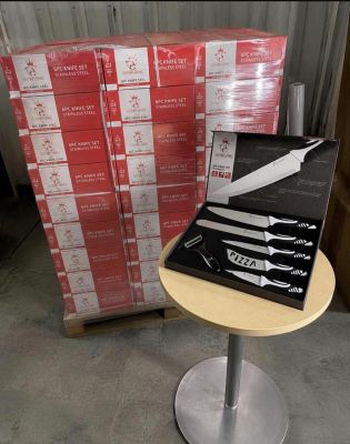 une boîte de couteaux posée sur une table à côté d'une pile de boîtes