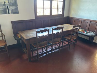 a table and chairs in a room with wood paneled walls