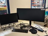 deux écrans d'ordinateur posés sur un bureau avec un clavier et une souris